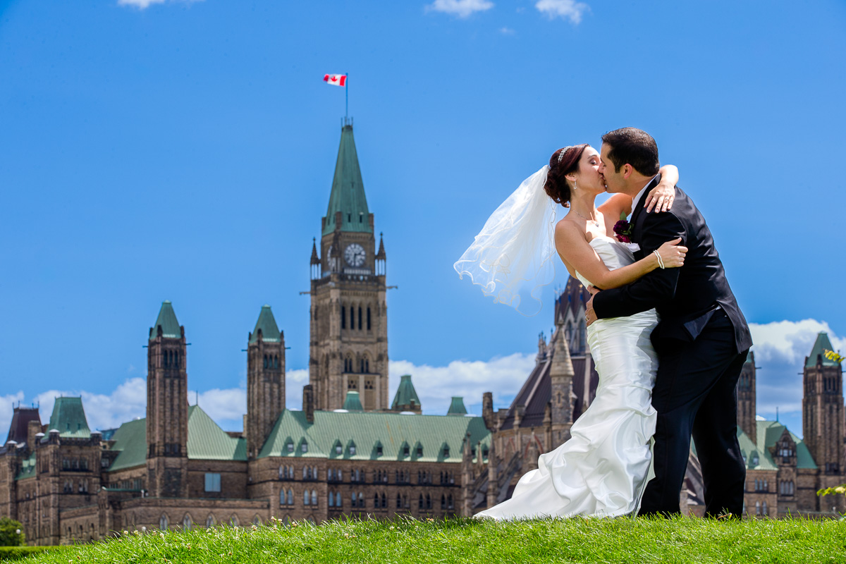 Recently married couple sharing a kiss during a wedding portrait session on Parliament Hill in Ottawa