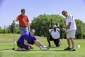 Four guys tee it off with a golf ball shaped like a football for a charity golf tournament.   Event photo by Jeffrey Meyer.