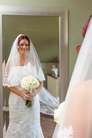 A bride looks in the mirror one last time before her wedding ceremony